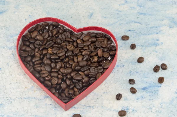 Коробка у формі серця, наповнена кавовими зернами — стокове фото