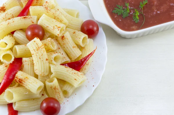 Pasta con tomates cherry y pimiento rojo servido con un tomate s —  Fotos de Stock