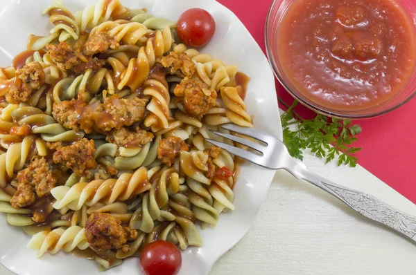 Pastas coloreadas con carne servida con un tazón de tomate natural sau —  Fotos de Stock