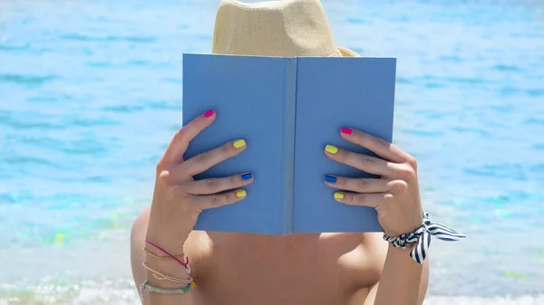 Girl reading a book on the beach — Stock Photo, Image