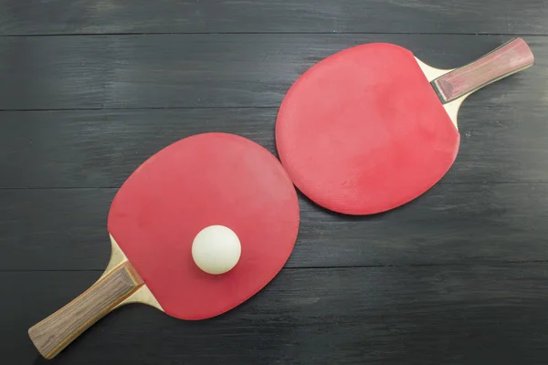 Duas raquetes de tênis de mesa vermelho no fundo escuro — Fotografia de Stock