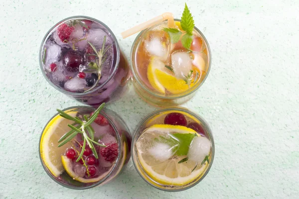 Four non alcoholic fruit cocktails arranged on the green table t — Stock Photo, Image