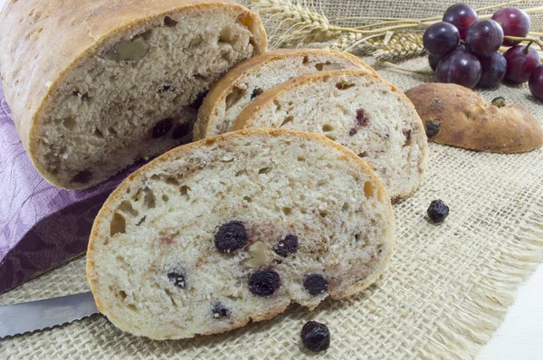 Fruit bread with aronia sliced on a wooden plate with dried aron — Stock Photo, Image