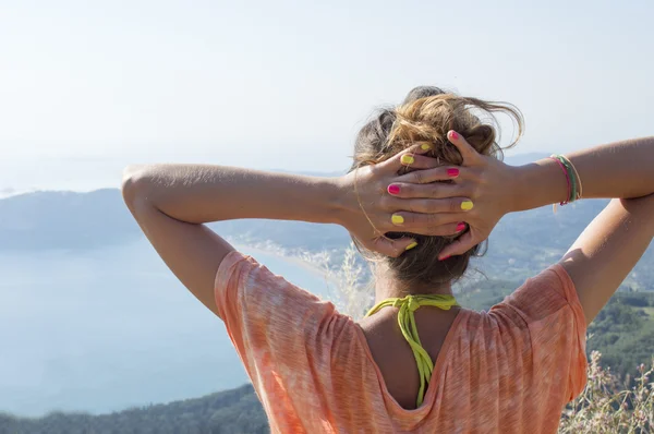 Dívka, čelí nevšední výhled na moře z hory — Stock fotografie