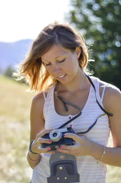 Красивый женский портрет на поле с ретро-камерой. низкий — стоковое фото