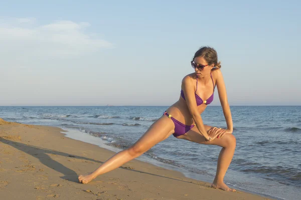 Dziewczyna w bikini, rozciąganie i ćwiczenia na plaży — Zdjęcie stockowe