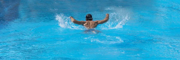 Homem nadando na piscina sozinho.Estilo borboleta. Férias . — Fotografia de Stock