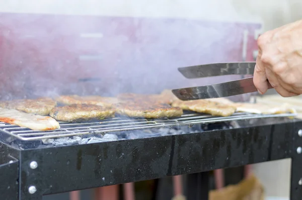 Uomo che prepara barbecue fumoso sulla griglia — Foto Stock