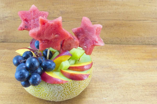 Insalata di frutta sana e attraente servita in un melone fresco su un legno — Foto Stock
