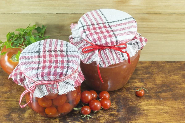 Frascos de ketchup casero y tomate cherry junto a cereza fresca — Foto de Stock