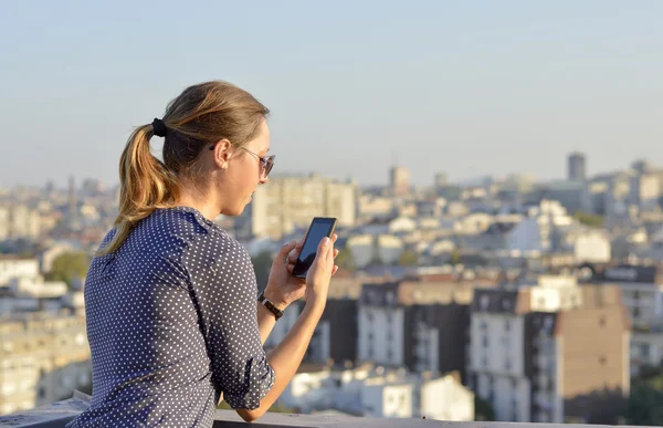 Femme utilisant son smartphone sur le toit — Photo