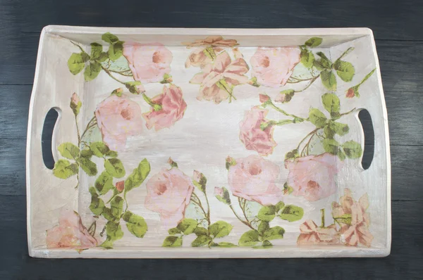 Decoupage decorated tray with flower pattern against  black wood — Stock Photo, Image