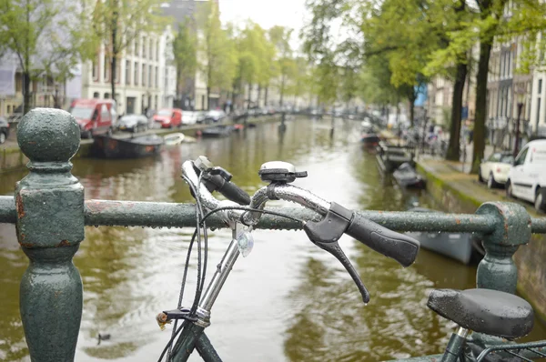 Fiets geparkeerd op een brug in Amsterdam — Stockfoto