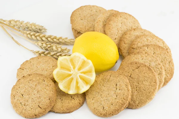 Integrální cookies a zdobený citronem na bílém pozadí — Stock fotografie