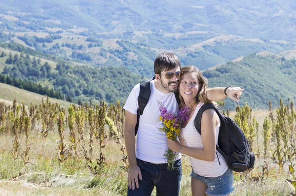 Casal de caminhantes com mochilas na montanha — Fotografia de Stock