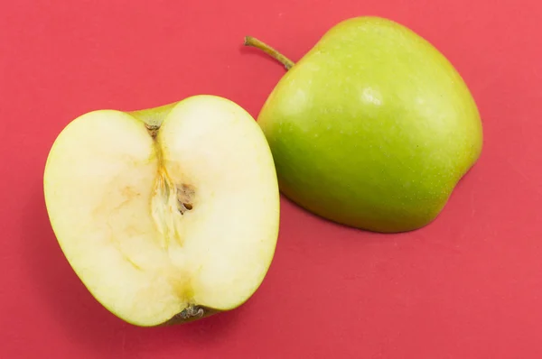 Bir elma kırmızı zemin üzerine iki yarısı — Stok fotoğraf