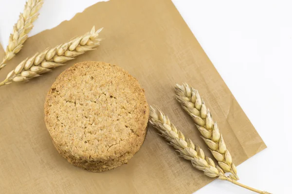 Integral cookies and wheat plant on the cooking paper — Stock Photo, Image