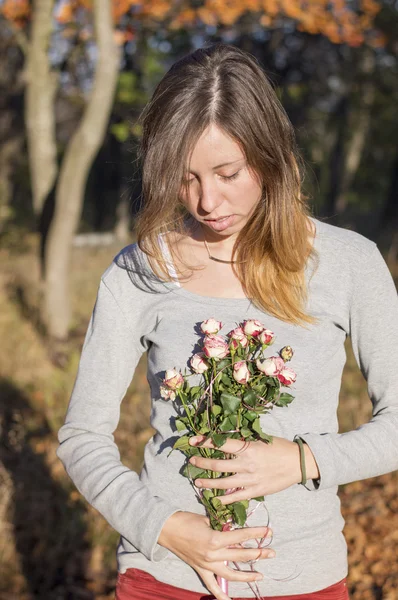 Chica morena feliz sosteniendo rosas en miniatura — Foto de Stock