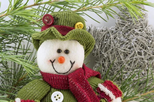 Snowman among fir branches with snow flakes — Stock Photo, Image