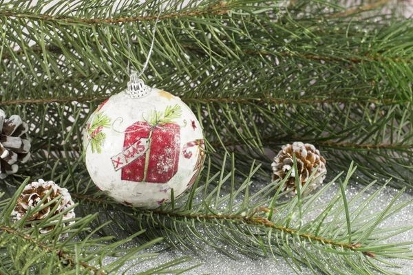 Weihnachtsschmuck und Tanne auf glänzendem Hintergrund — Stockfoto