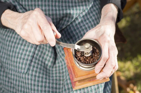 Velhas mãos moendo café em um moedor de café vintage — Fotografia de Stock