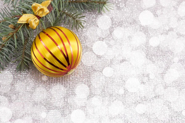 Weihnachtsschmuck und Tanne auf glitzerndem Hintergrund — Stockfoto