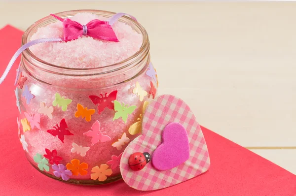 Купа сіль в банці поруч з рожевим рівнинним серцем — стокове фото