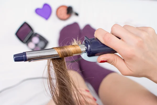 Menina endireitando seu cabelo na cama — Fotografia de Stock