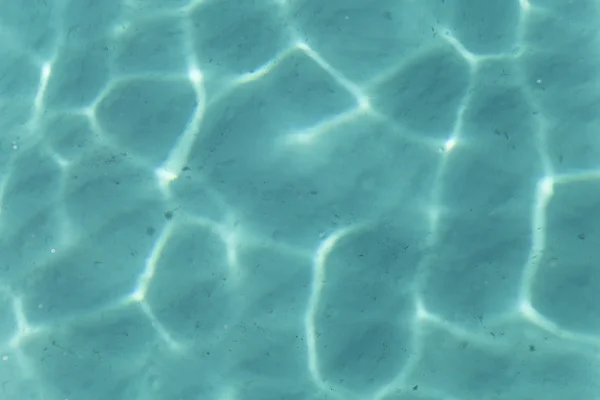 Brilhando fundo ondulação de água turquesa — Fotografia de Stock