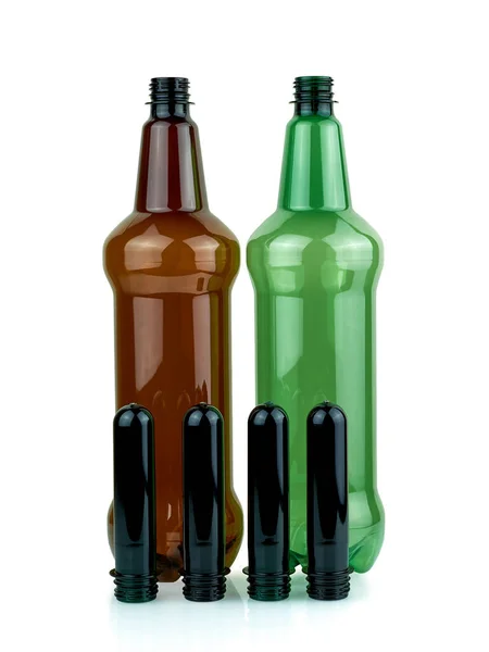 Plastic bottles and PET preforms. Manufacturing of plastic PET bottles. Brown and green plastic bottle on white background