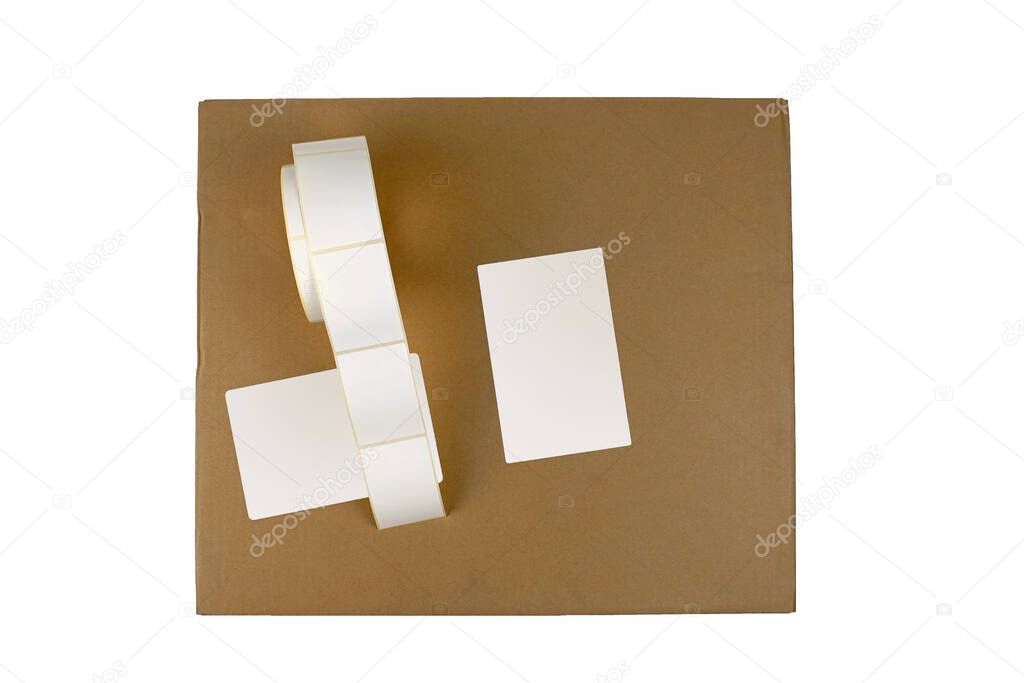 Stickers on a cardboard box, top view, isolate on a white background. Label reel for printers. Labels for thermal transfer printing. Marking boxes with white stickers.