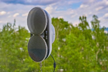 Robot pencere camını temizler. Bir çamaşır robotu pencereyi dışarıdan temizler. Yüksek binaların pencerelerini güvenli bir şekilde yıkamak. Cam Temizleme için Robotik Pencere Temizleyici.