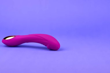 Mor arka planda bir vibratör, kopyalama alanı. Kadın vibratörü, seks zevki kavramı. Pembe Yetişkin Seks Oyuncağı.