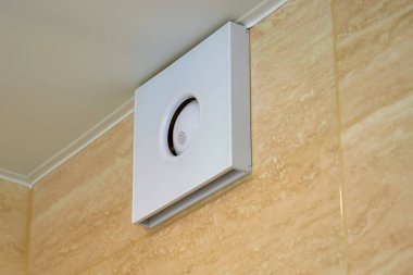 Banyodaki havanın havalandırılması. Banyoda rahat bir mikroklimayı muhafaza etmek. Banyo duvarında elektrikli vantilatör var.