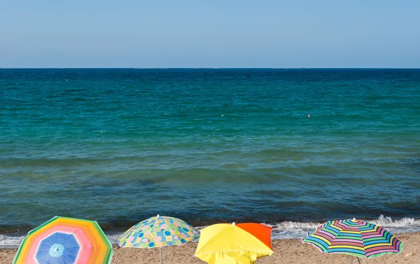 Vier strand parasols in een strand van Sicilië in de zomer — Stockfoto