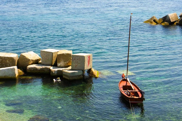 Kleine zeilboot afgemeerd in de buurt van de kust — Stockfoto