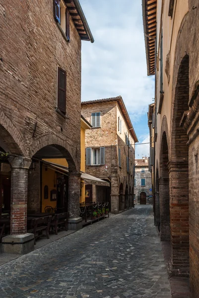 Calle estrecha con adoquines en la pequeña ciudad medieval de Urbania (región de Marche, Italia ) — Foto de Stock