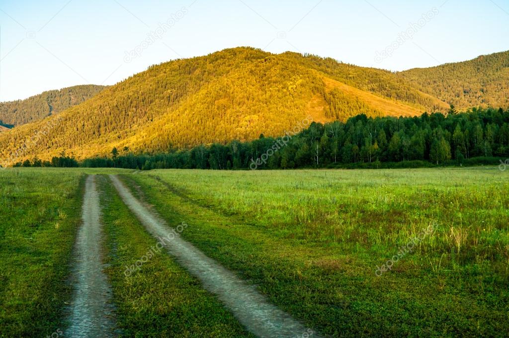 Dirt road runs through the valley in the mountains