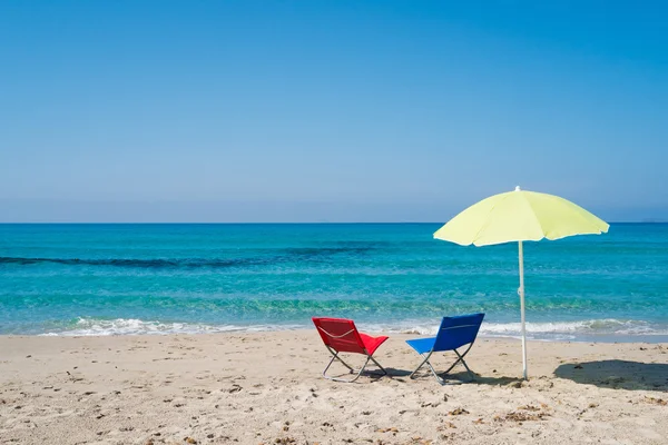 Beach umbrella and lounge chairs — Stock Photo, Image