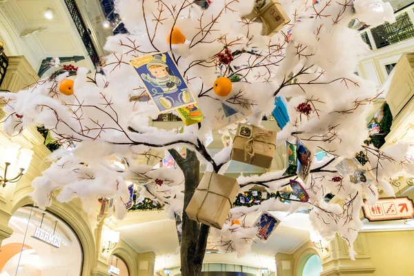 Weihnachtsspielzeug und Geschenke hängen an einem künstlichen Baum — Stockfoto