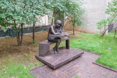 Masasında oturan bir öğrenci kızın bronz heykel