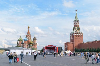 Kırmızı kare inşa geçici bir sahne yakınındaki insanlar yürümek