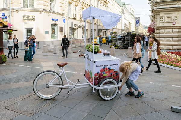 Girl sets the counter with a refrigerator, attached to the bike