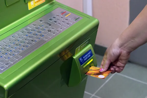 Мужчина (женщина) вставляет пластиковую платежную карту в слот банкомата — стоковое фото