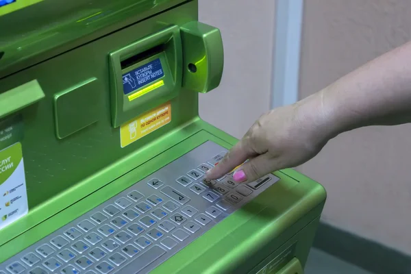 Мужчина (женщина) набирает ПИН-код на клавиатуре банкомата termi — стоковое фото