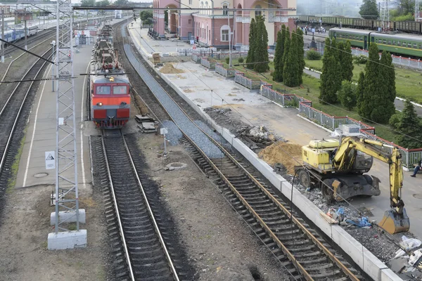 Elektrický vlak přijíždí na vlakové nádraží. Opravy silnic a nástupiště na vlakovém nádraží — Stock fotografie