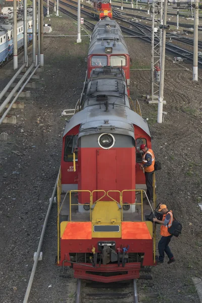 Diesel typ Chme3t-7451 je na kolejích na vlakovém nádraží. Řidič s asistentem na sobě kombinézu, zavřete do kabiny a slézt z lokomotivy. Pohled shora na přední — Stock fotografie