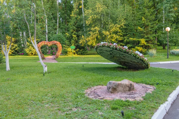 Топиарная фигура цветов в форме огромного циферблата часов в парке — стоковое фото