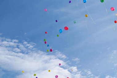 Birçok renkli balon bulutlar ile mavi gökyüzünde uçmak