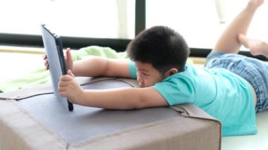 Asyalı Çinli çocuk akıllı telefon oynuyor, çocuk telefon kullanıyor ve oyun oynuyor, bağımlı oyun ve çizgi film oynuyor.